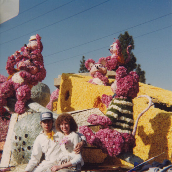 Two people sit on a decorated Cal Poly Rose Parade float in the 1980s