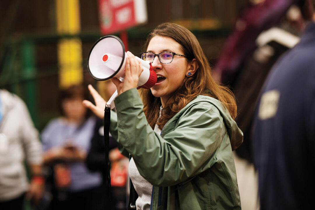 A student leader speaks to volunteers using a megaphone