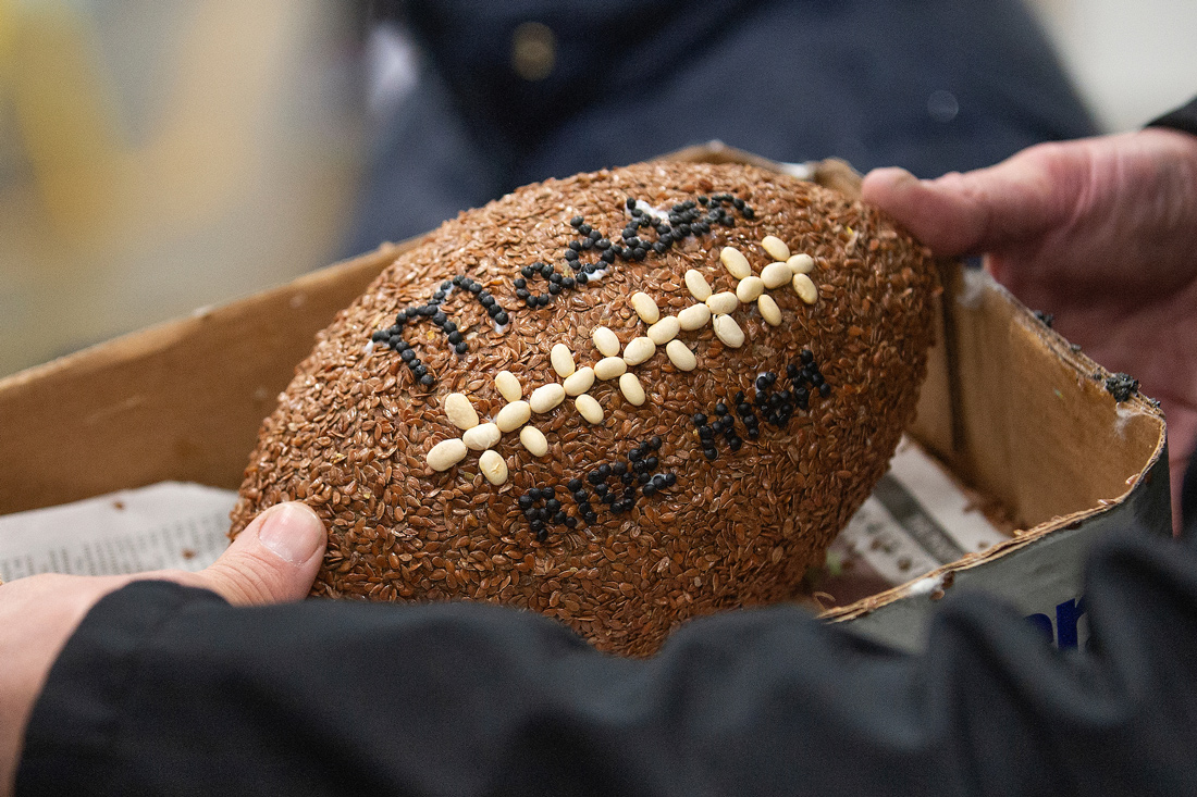 A Rose Parade float decoration of a football decorated with organic materials with the text Madden Ride High