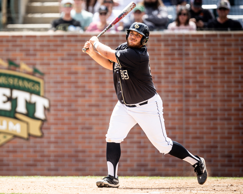 A Cal Poly baseball player swings the bat at home plate