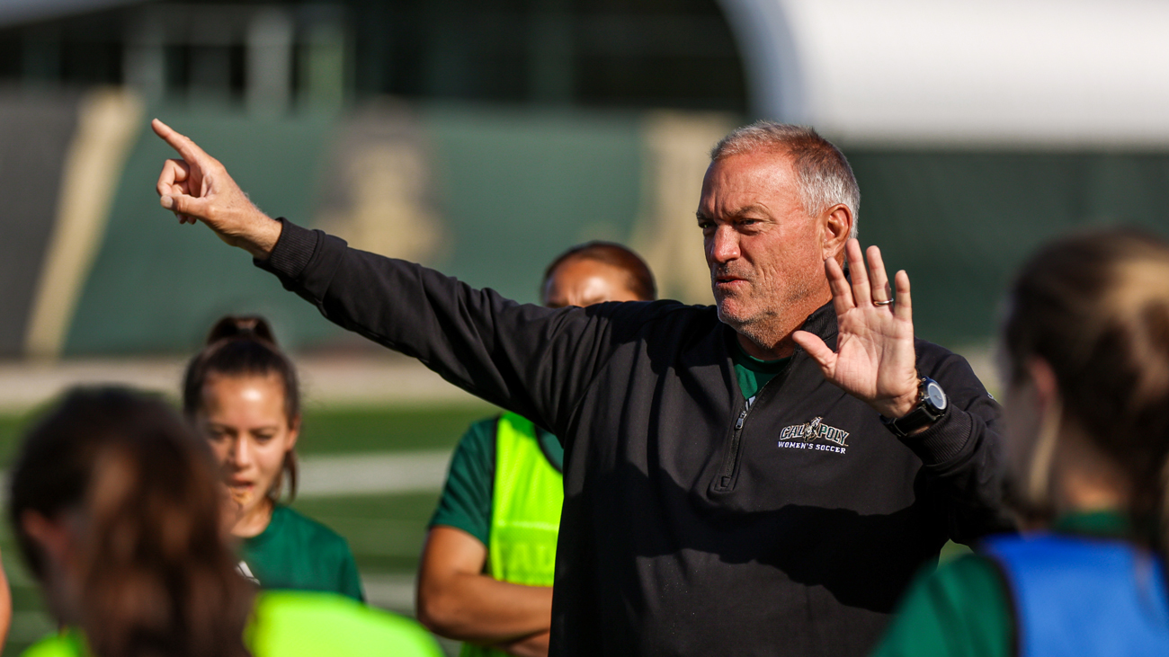 Cal Poly women's soccer head coach Alex Crozier points while giving instructions to women's soccer players