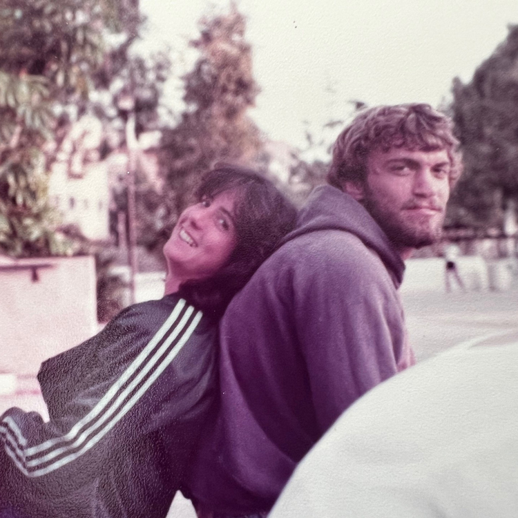 A young Judy King leans on the back of a young Alex Crozier