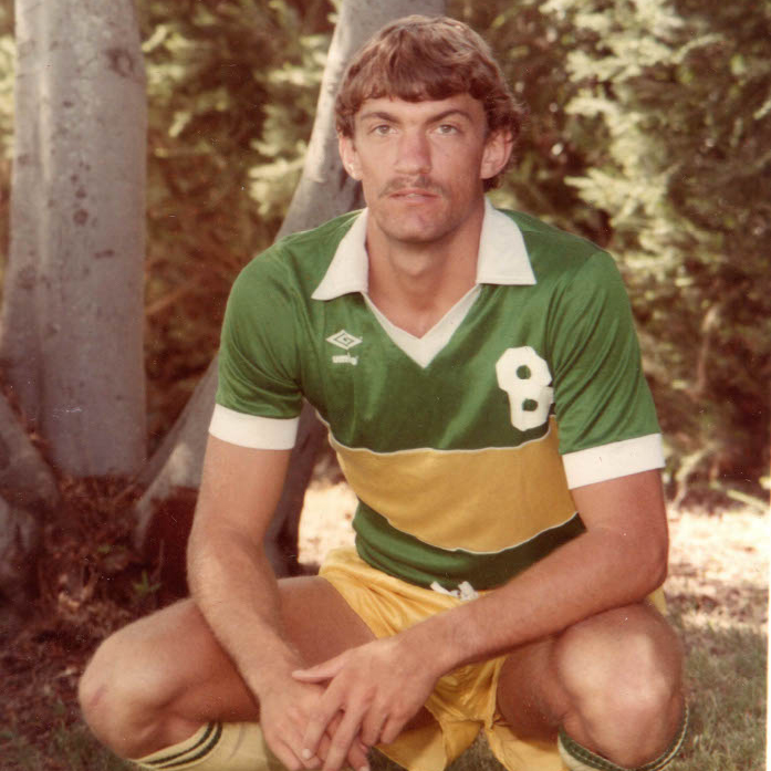 A young Alex Crozier poses in a green and gold Cal Poly men's soccer jersey with the number eight