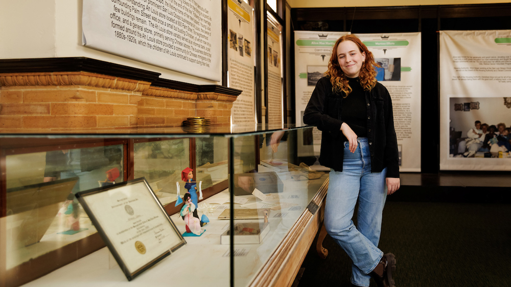 A student leans on a glass case in a historical exhibit