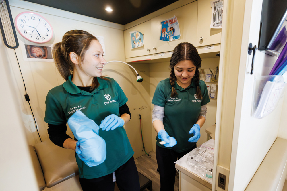 Two health care staff members cleaning a clinic treatment room