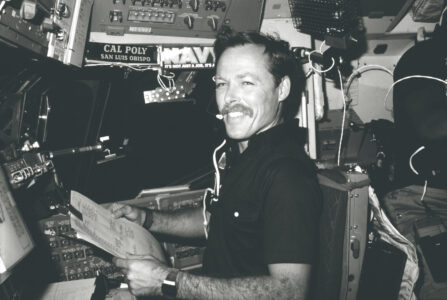 Astronaut Robert L. Gibson, 41-B pilot, reviews some teleprinter copy.
