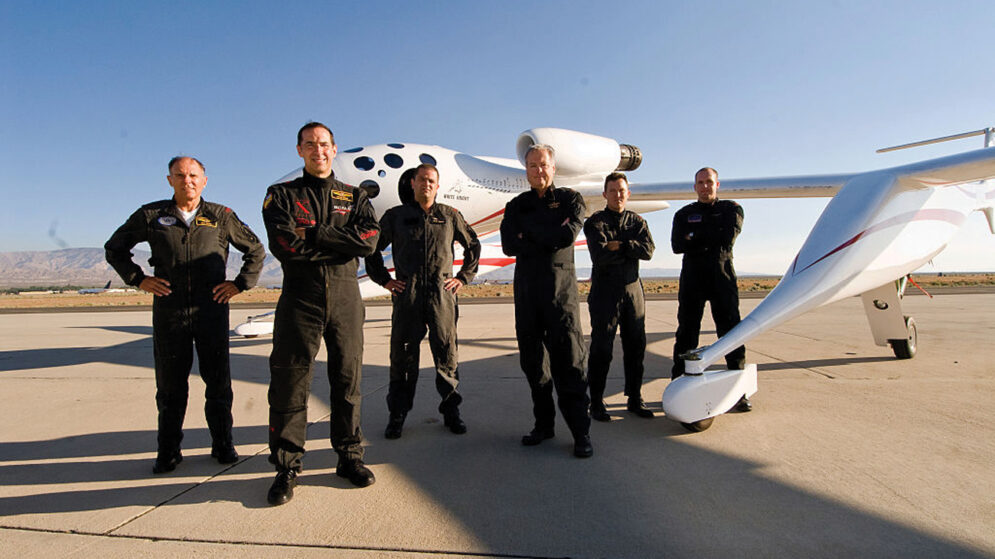 The SpaceShipOne spacecraft with six test pilots standing in front of it