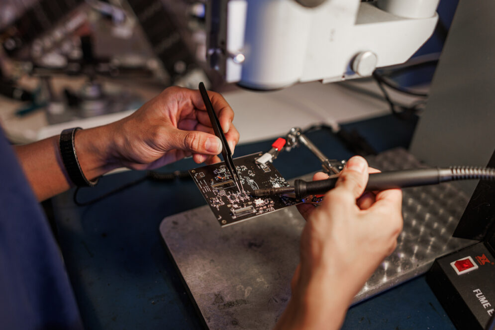 A student solders a circuit board