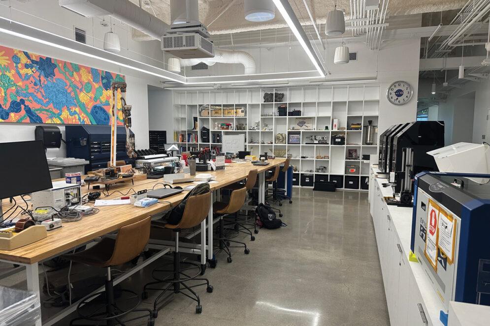 The “Maker Center,” an engineering lab at Jet Propulsion Laboratory, with work benches, colorful art on the walls and computers.
