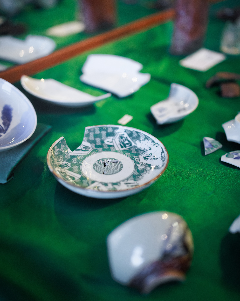 Fragments of a white tea saucer with a teal design.