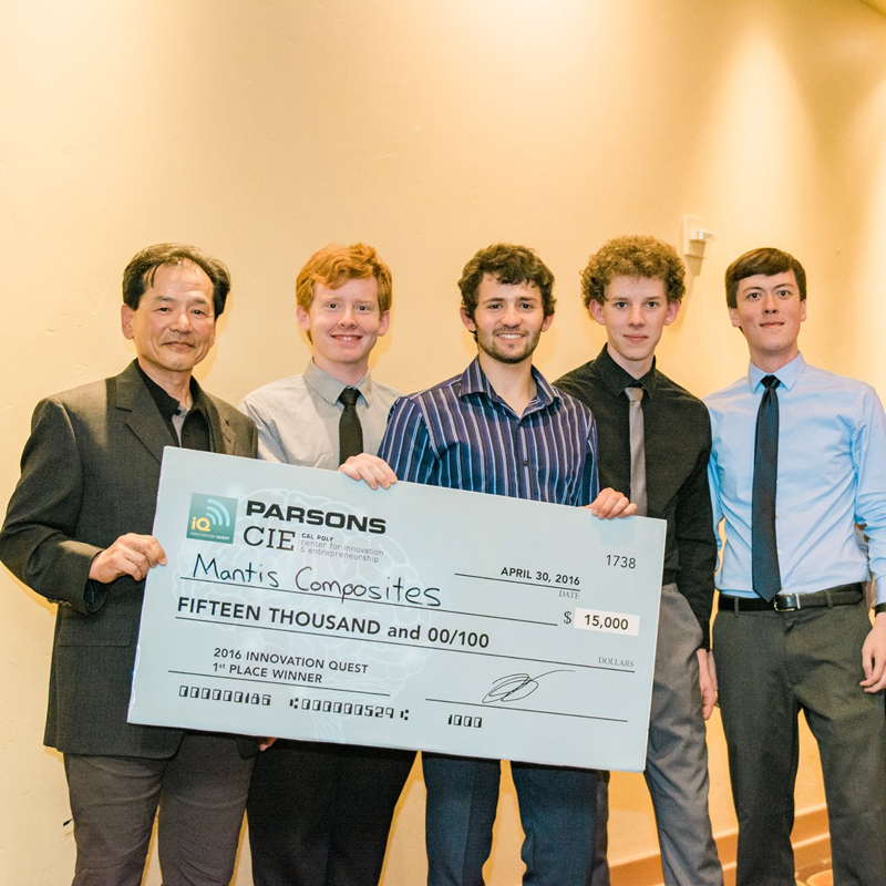 The members of Mantis Composites stand with Carson Chen holding an oversized check after an event win
