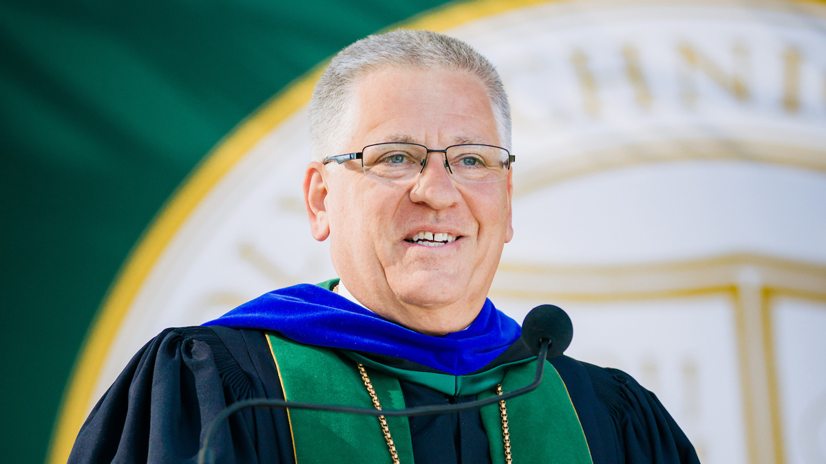 President Jeffrey D. Armstrong in academic regalia speaking at a commencement event