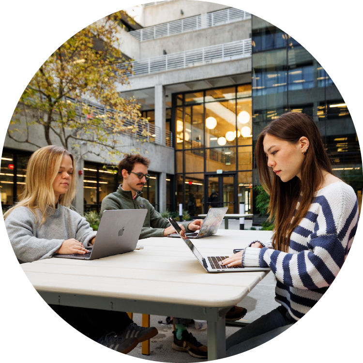 Three people study at a courtyard in Cal Poly's library