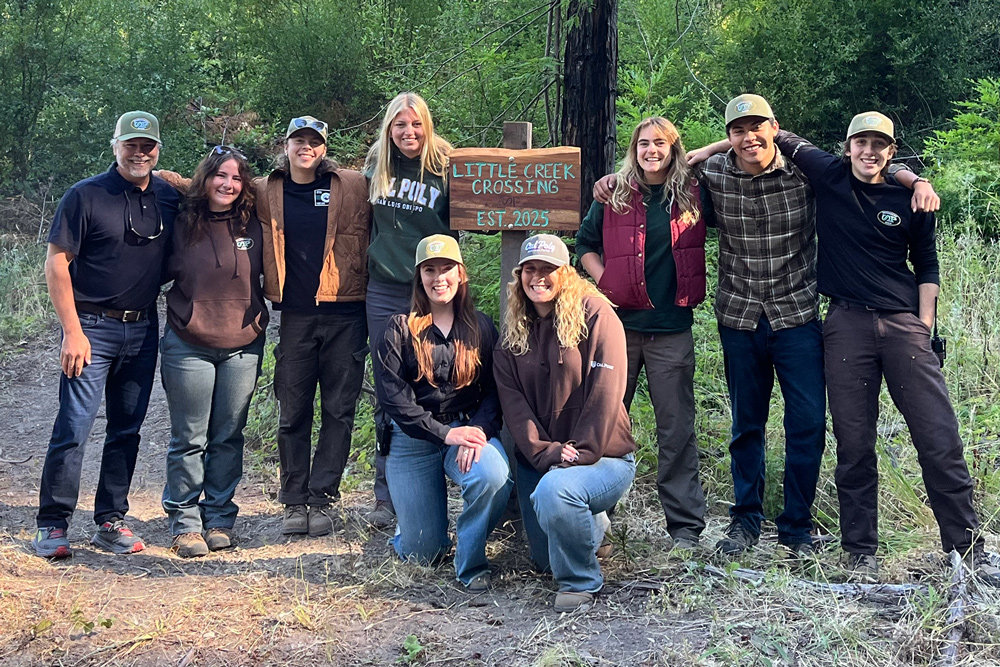 An administrator stands with eight students at a creek crossing sign at Swanton Pacific Ranch
