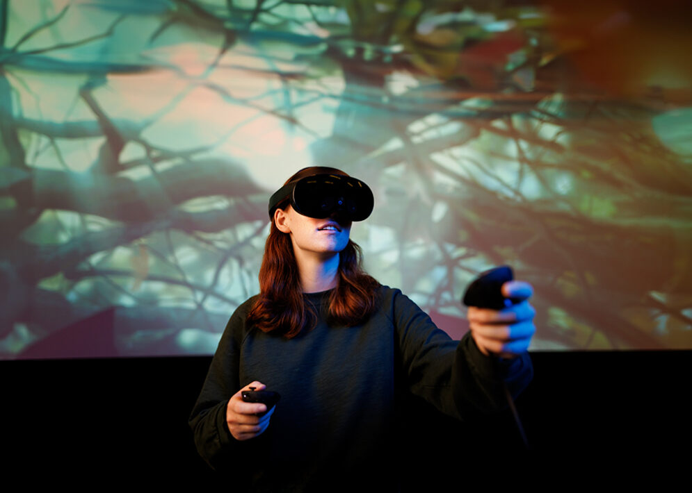 A student operating a virtual reality headset and controller.