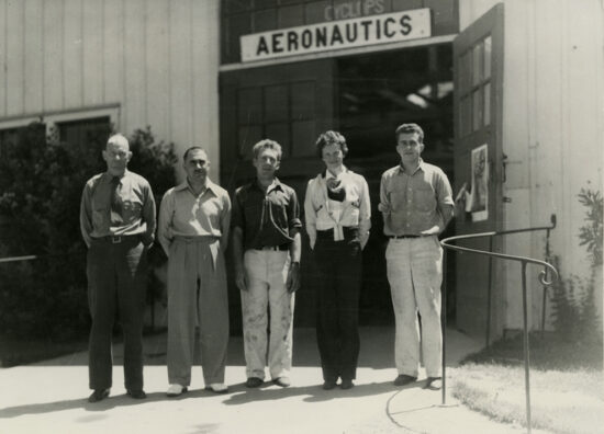 Amelia Earhart standing with Cal Poly faculty and students outside of the aeronautics building.