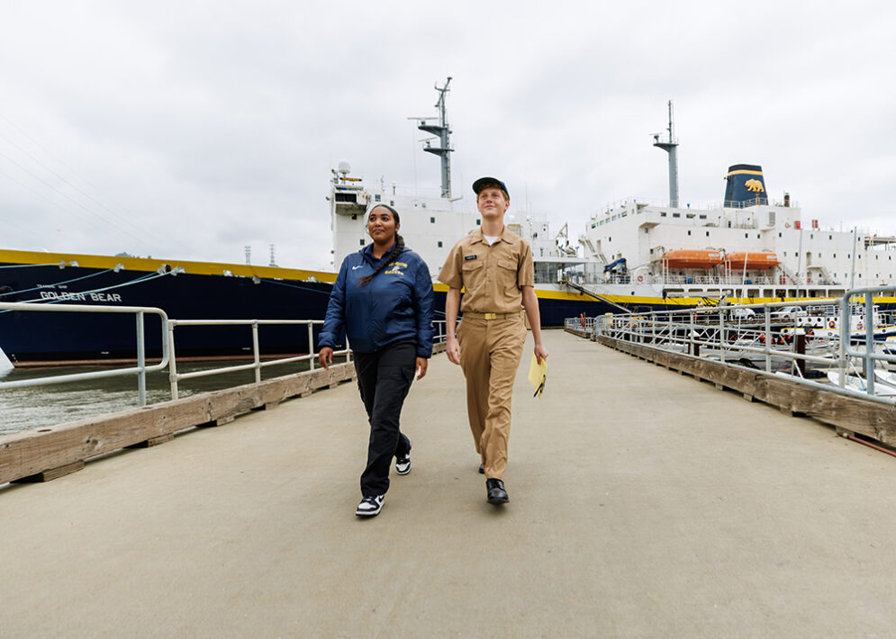 Two Cal Poly Maritime Academy students walking along the dock in front of TSGB.