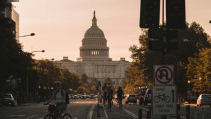An evening view of Washington, D.C., with the Capitol in the background and pedestrian and bike traffic in the foreground