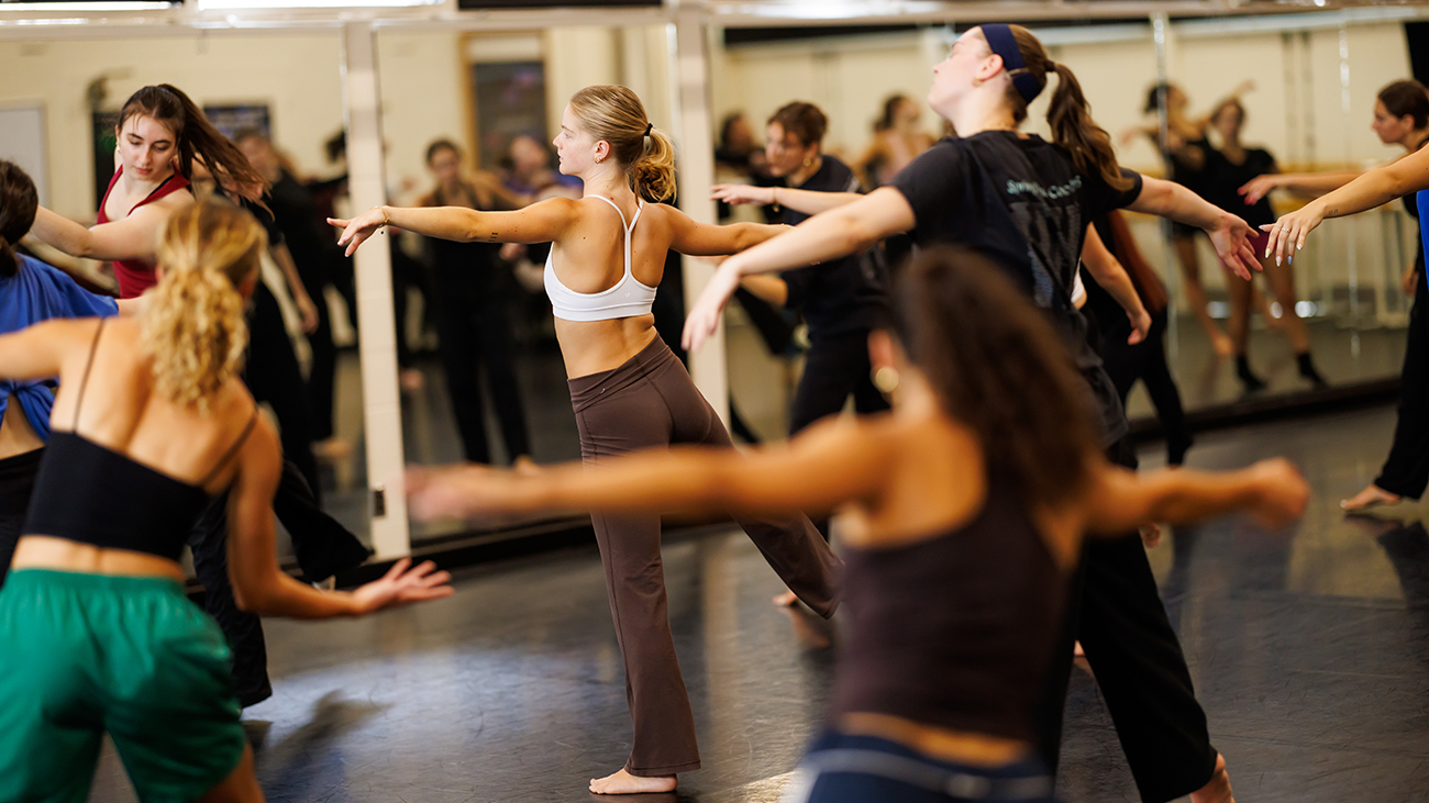 Dancers in the Orchesis dance company rehearse in front of mirrors on campus