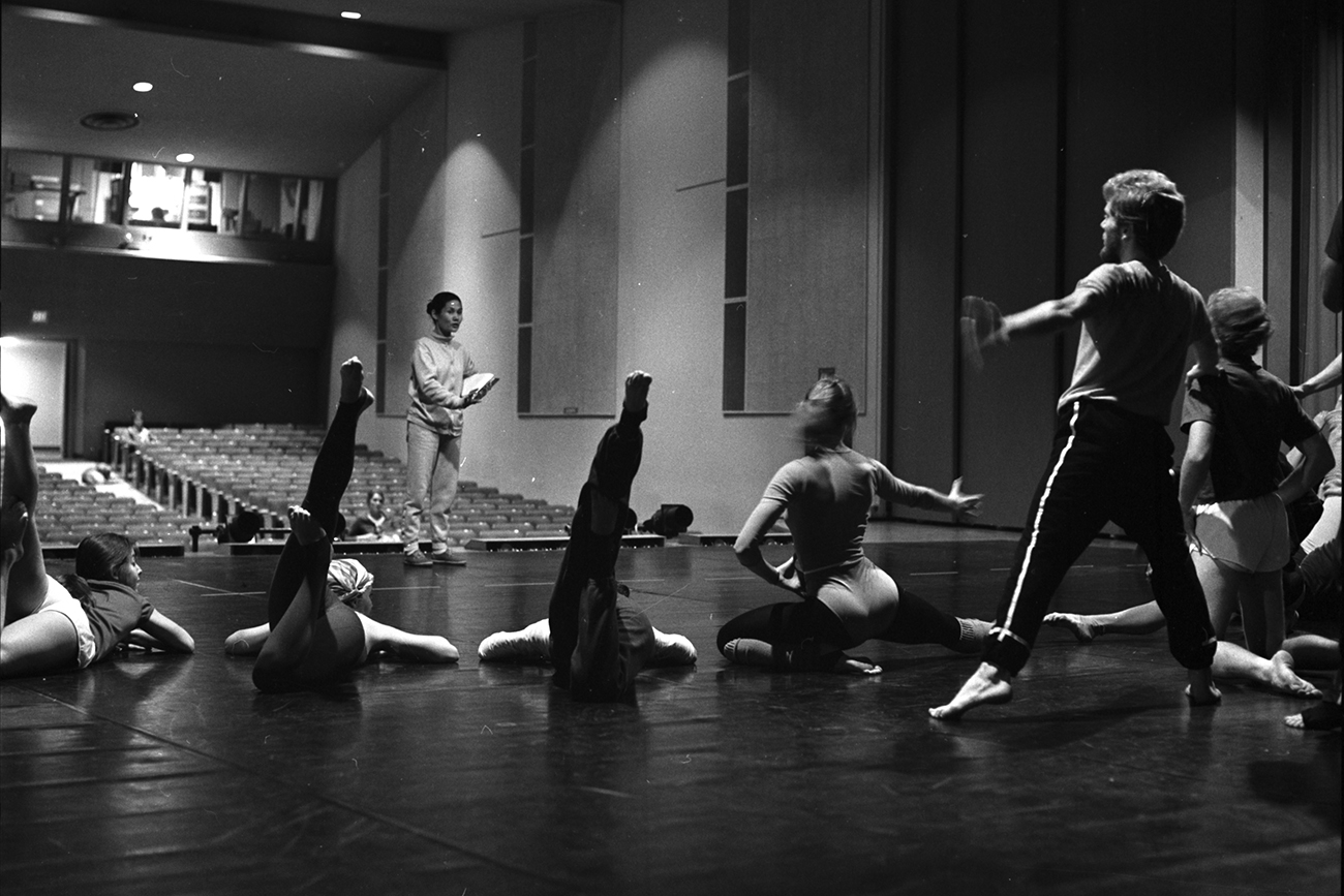 An archive image of student dancers rehearsing on stage with emeritus professor Moon Ja Minn Suhr