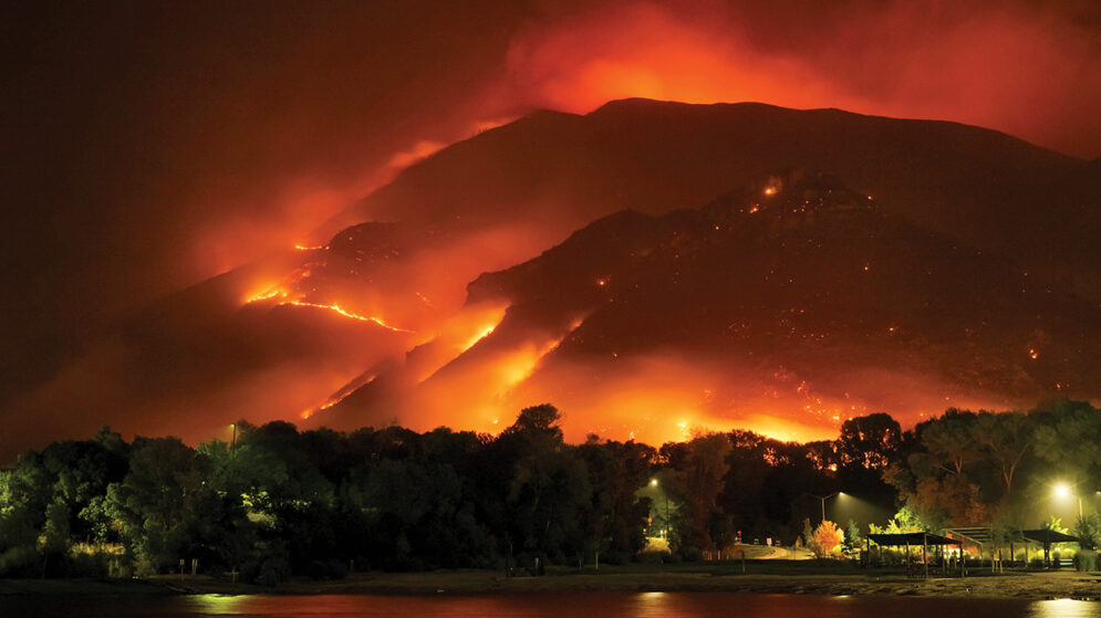 A wildfire sweeps over a hillside