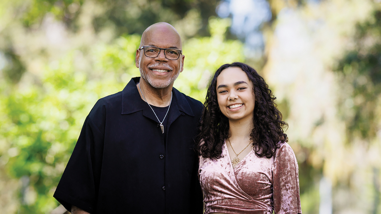 A man and a young woman smile in a portrait outdoors