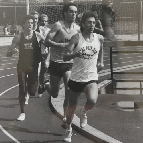 A black-and-white image of athletes running around a track