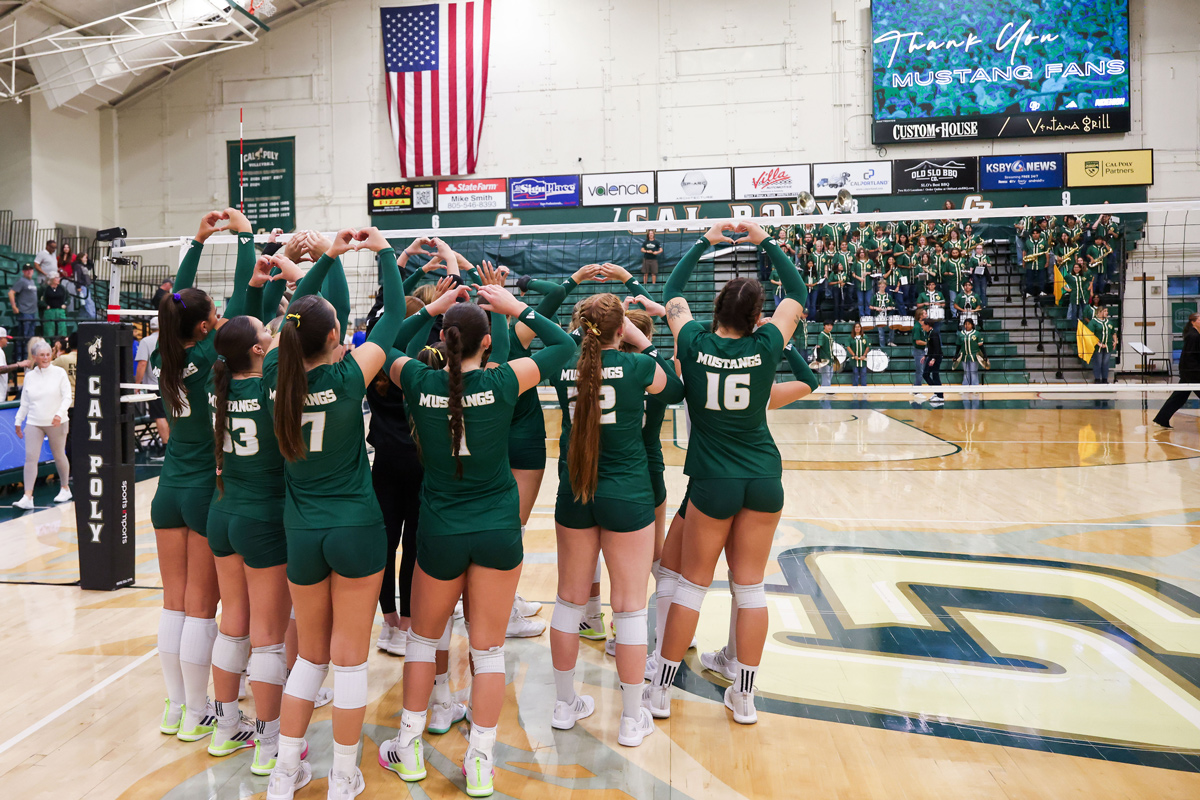The Cal Poly volleyball team waves to the university band from the floor of Mott Gym