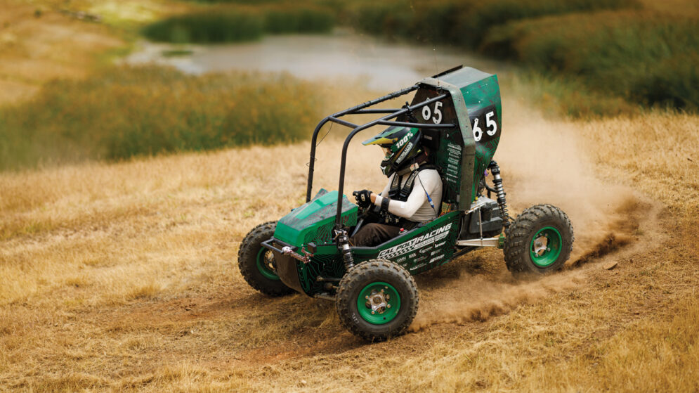 A Cal Poly Racing Baja car speeds down a dirt race course in San Luis Obispo