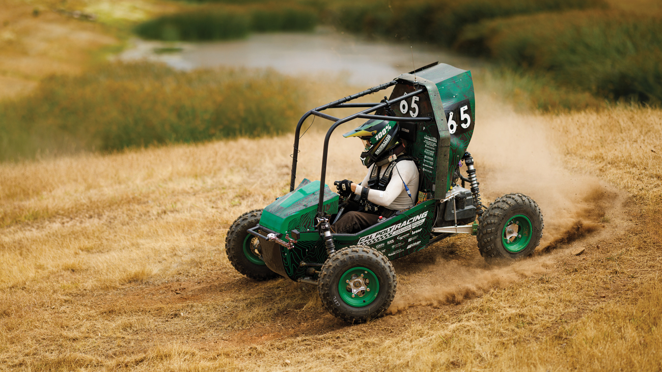 A Cal Poly Racing Baja car speeds down a dirt race course in San Luis Obispo