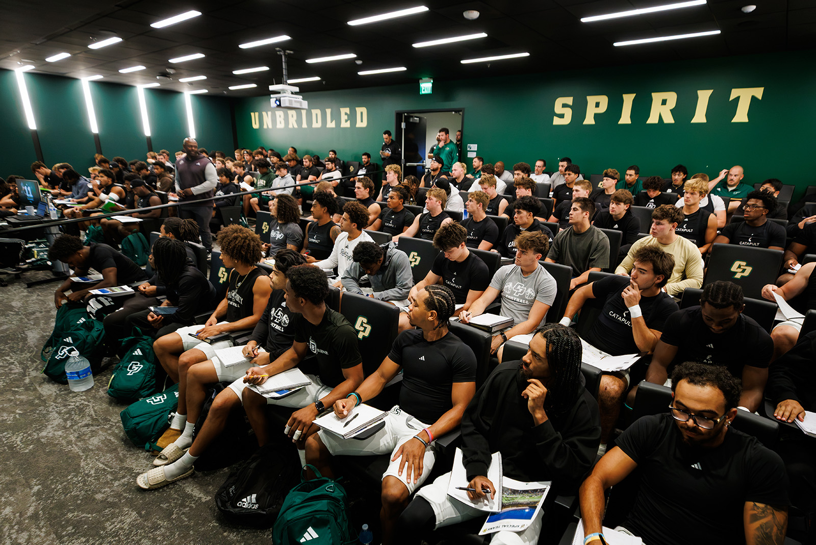 Players and coaches at a team meeting in the Madden Center.