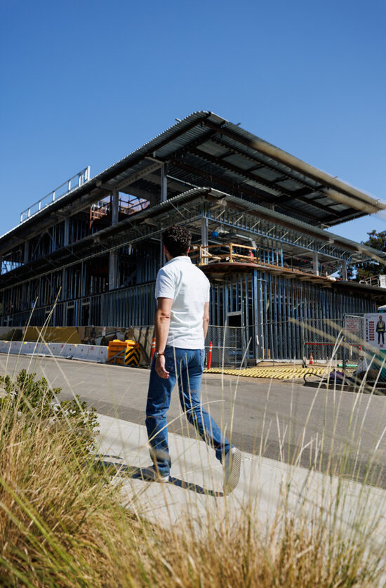 A man walks past a construction site on campus