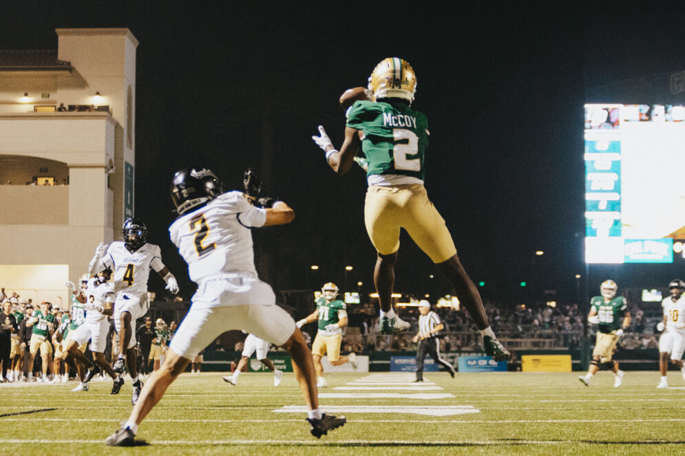 A Cal Poly wide receiver jumps to catch a football pass in the end zone.