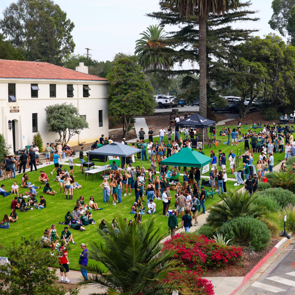 Students relax on a lawn during a Cal Poly student tailgate event before a football game on campus.