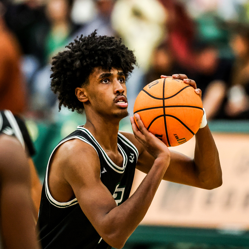 A Cal Poly men's basketball team member prepares to shoot the basketball during a game.