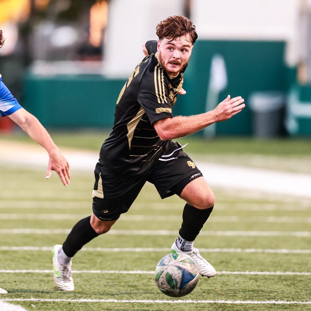 A Cal Poly men's soccer player advances up field with the ball