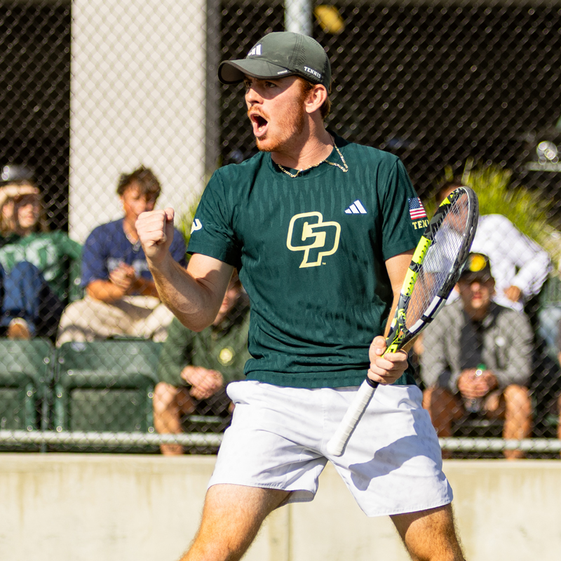 A Cal Poly men's tennis team member pumps his fist after a point during a match.