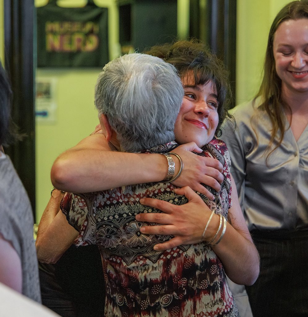 A Yoshida family member and a student embrace at a historical exhibit